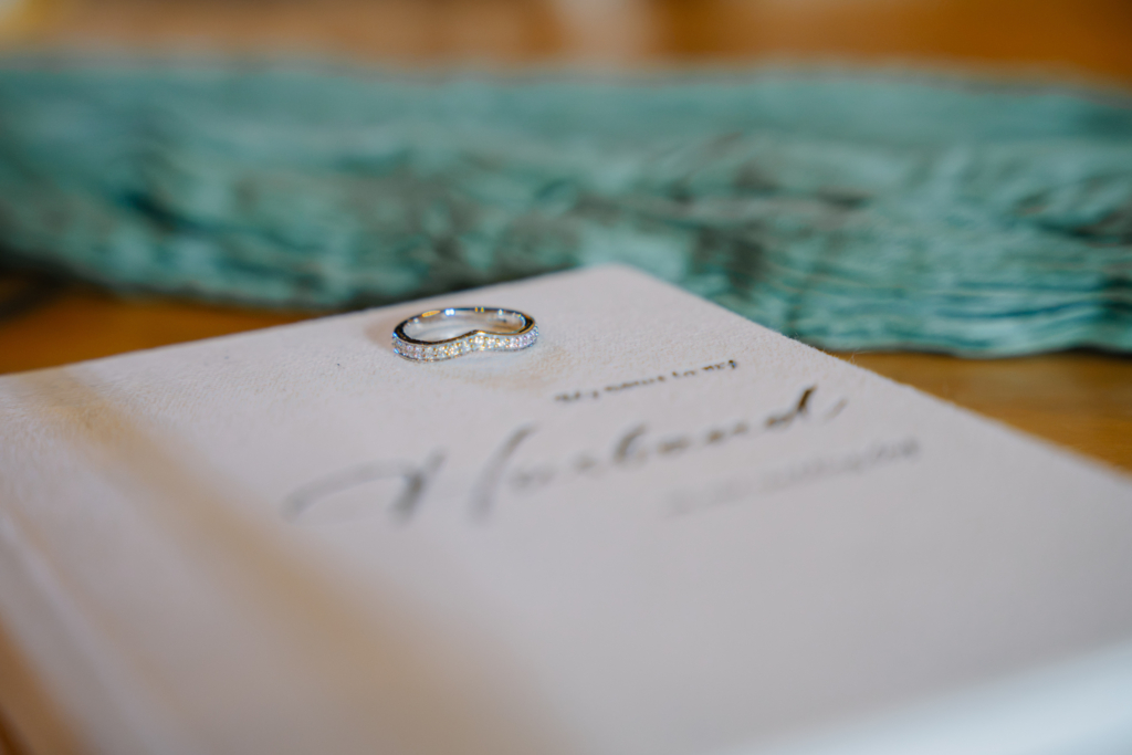 Wedding rings resting on the order of service, a moment captured with ceremony only wedding photography