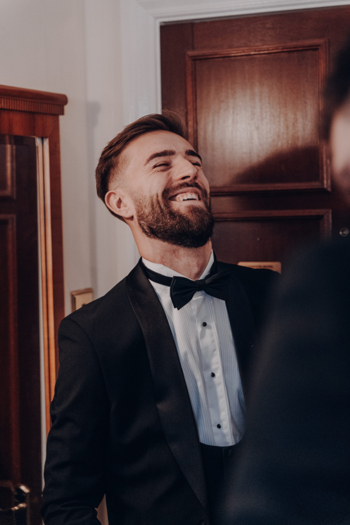 Groom laughing during the celebrations, the kind of moment to consider when deciding how to choose a wedding photographer