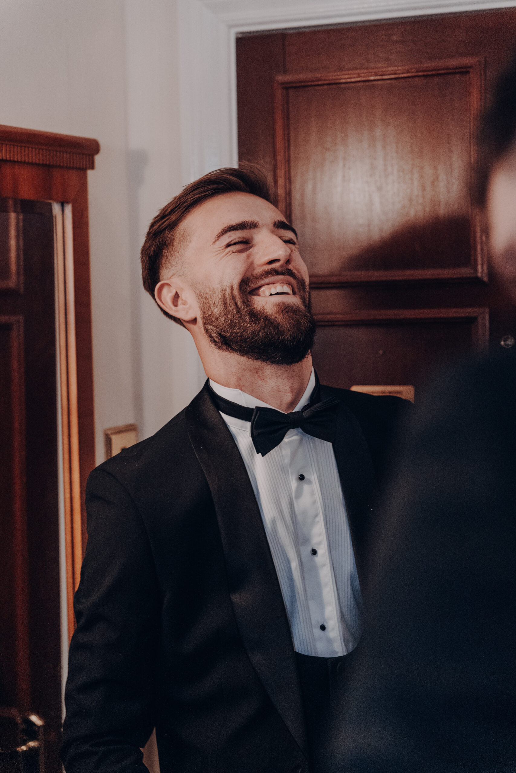 Groom laughing during the celebrations, the kind of moment to consider when deciding how to choose a wedding photographer
