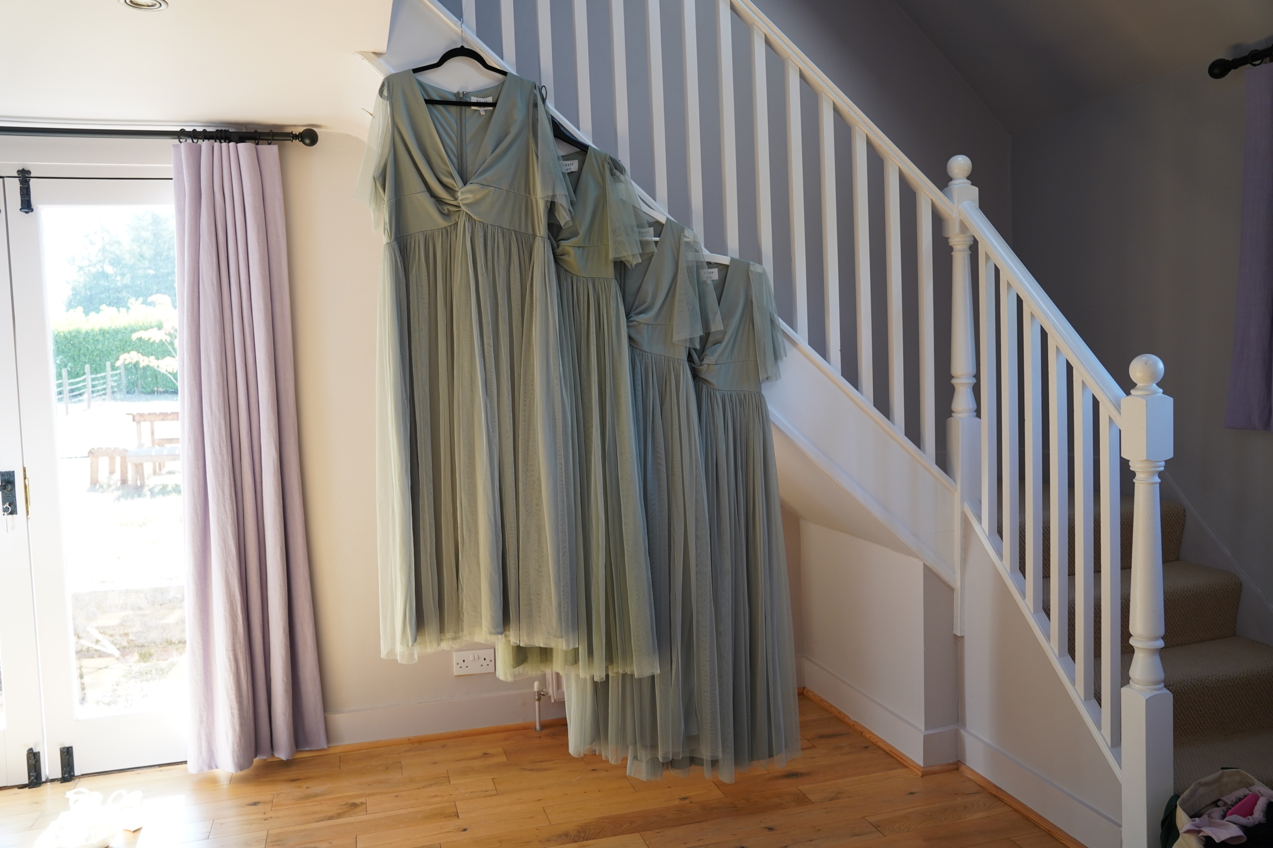 Bridesmaid dresses hanging by the stairs on a Hampshire wedding morning