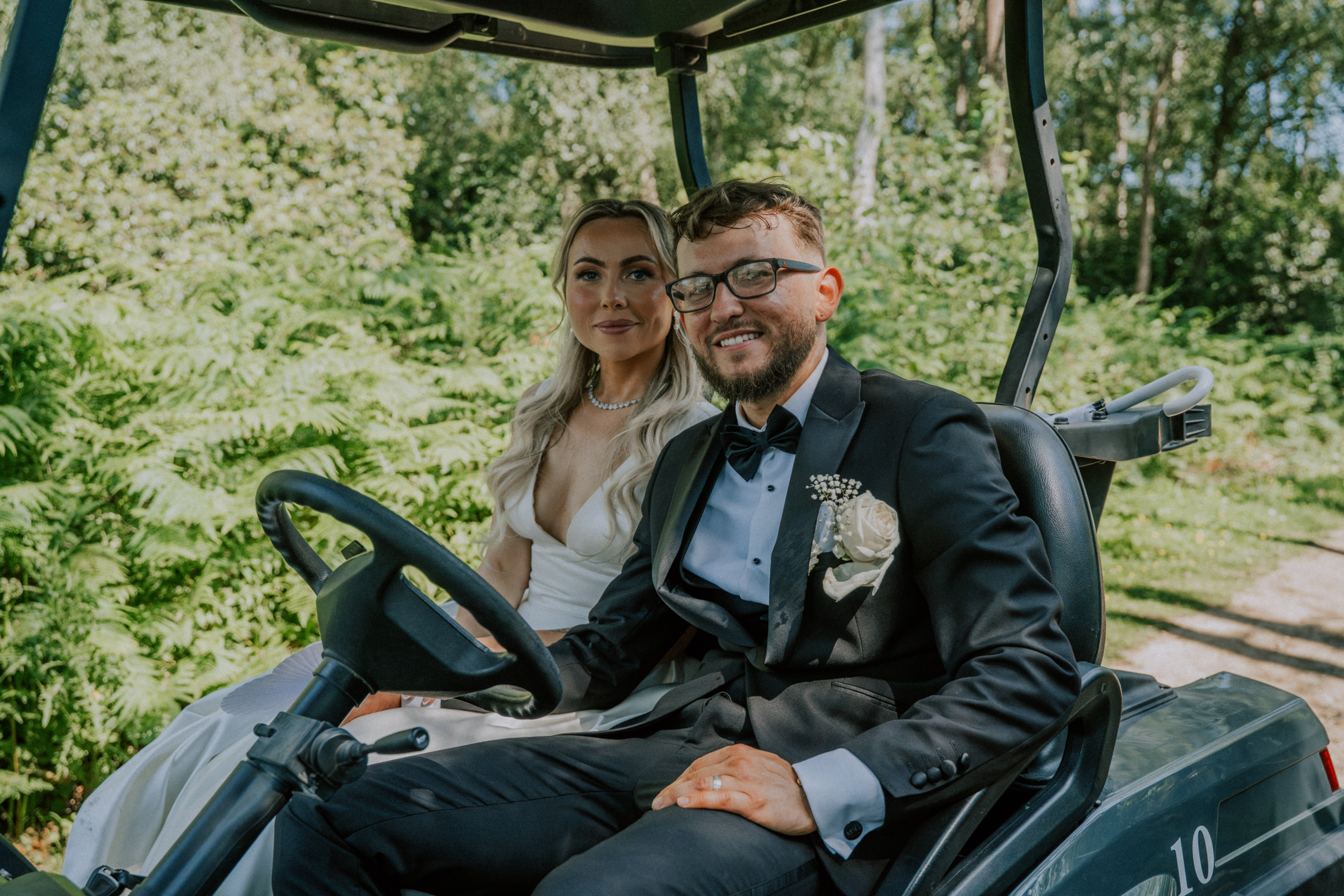 Wedding Content Creator Southampton 1 A smiling couple sitting in a golf buggy after their ceremony