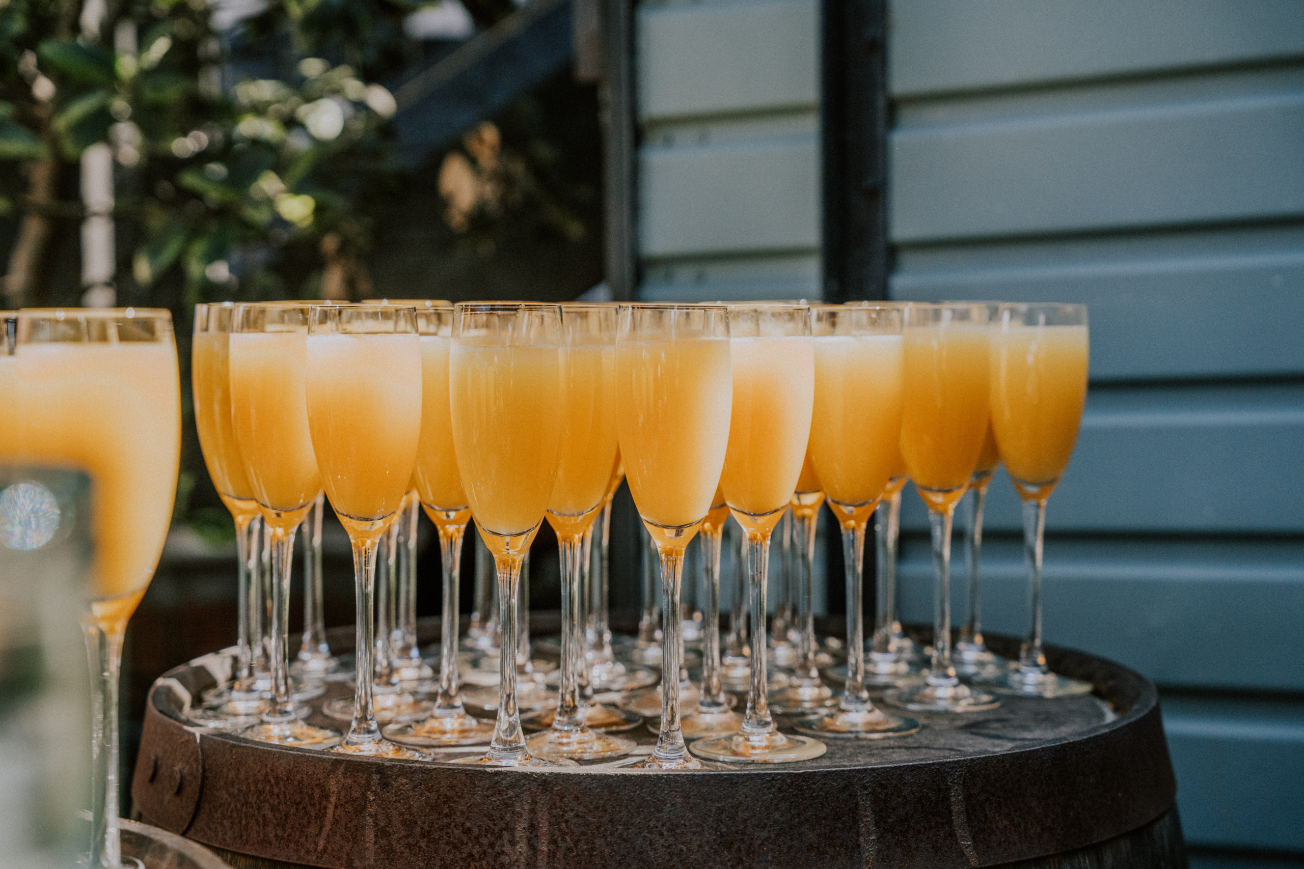 Wedding Content Creator Southampton 2 Glasses of sparkling Buck’s Fizz lined up on a wooden barrel
