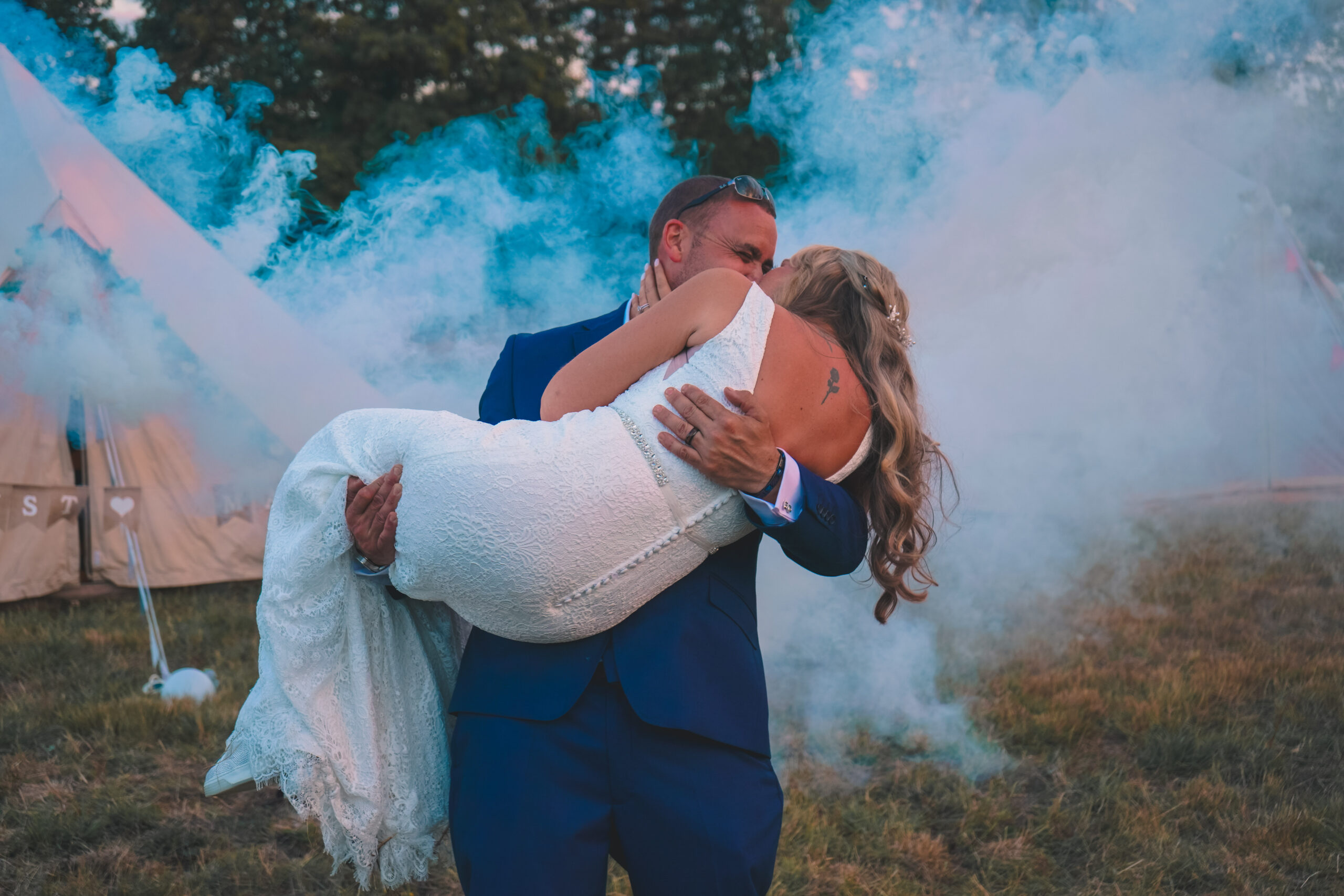 Groom lifting bride with coloured smoke, a fun moment captured by a wedding content creator