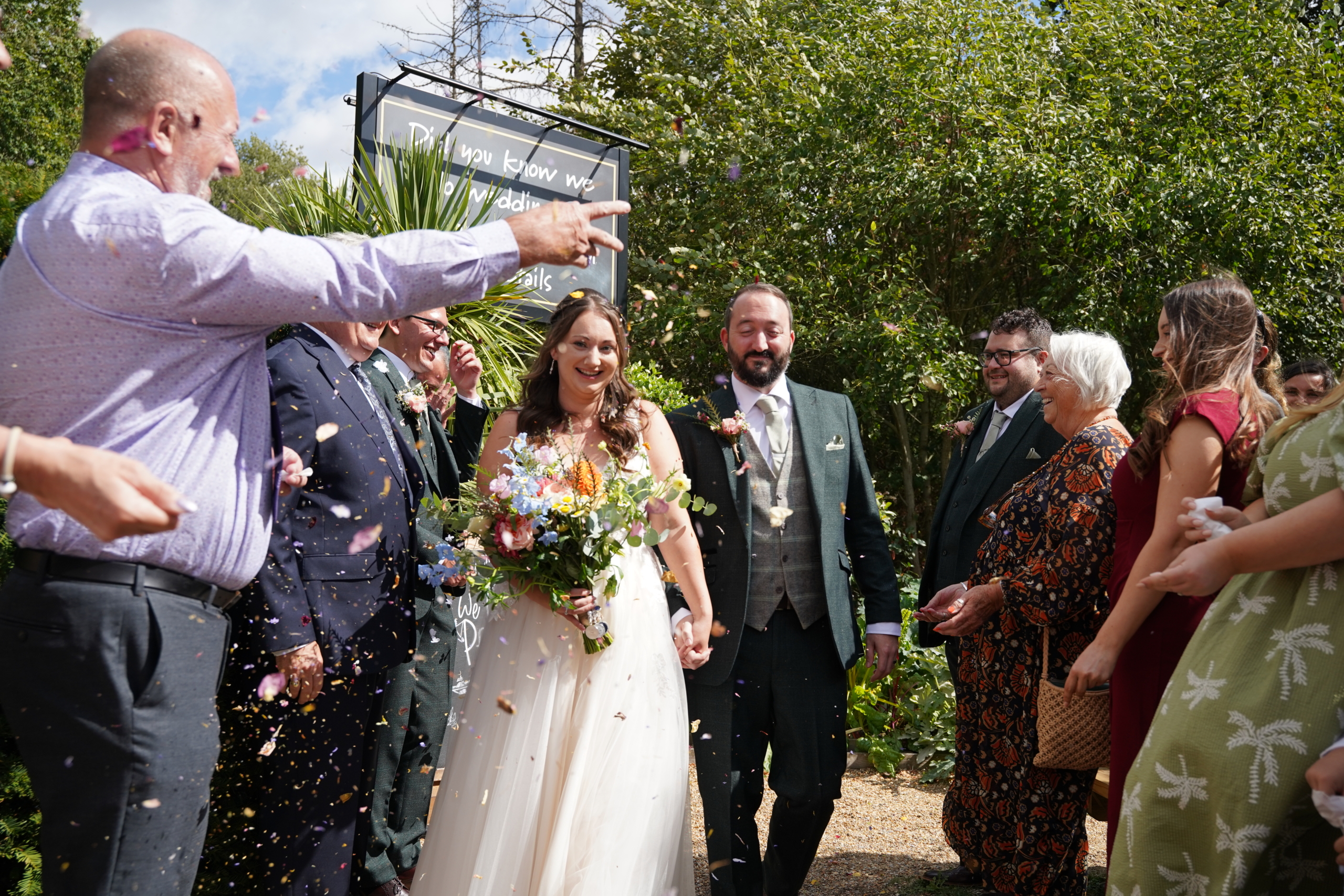 Newlyweds walking through a shower of confetti at a Hampshire wedding