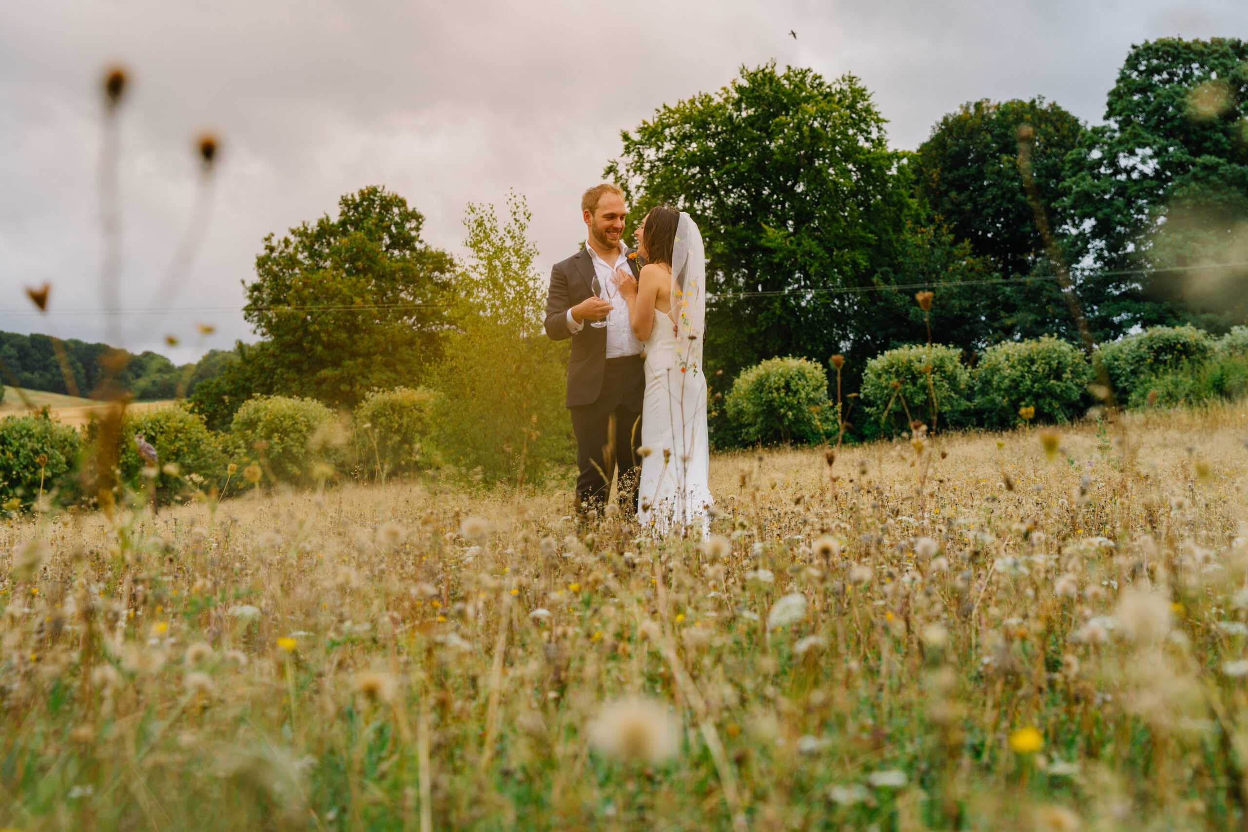 Bride and groom in a meadow with trees behind, captured by a wedding photographer in Havant