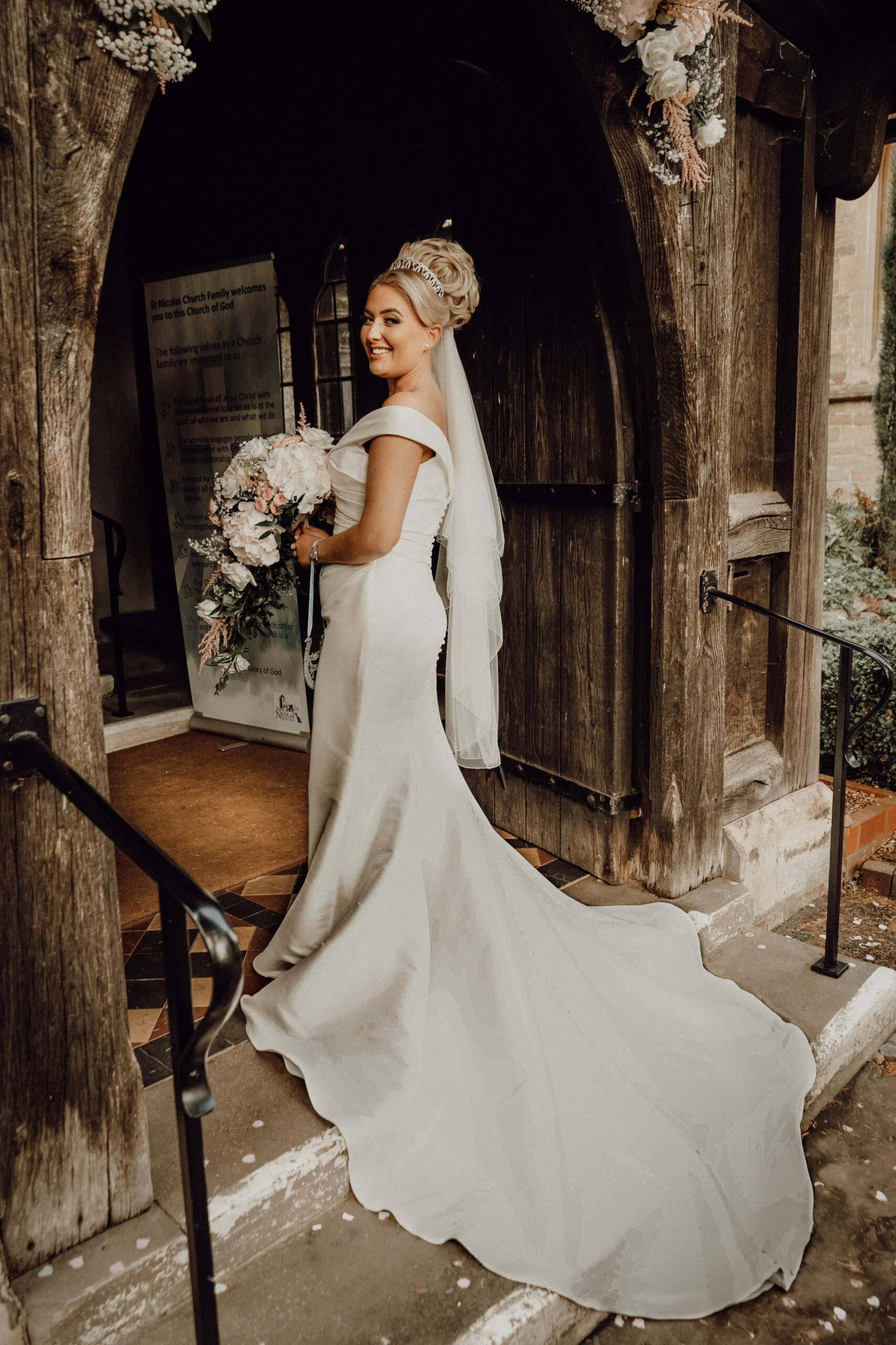 Wedding Photographer in Netley Venues Bride in a fitted gown at a rustic wooden doorway, photographed by a wedding photographer in Netley