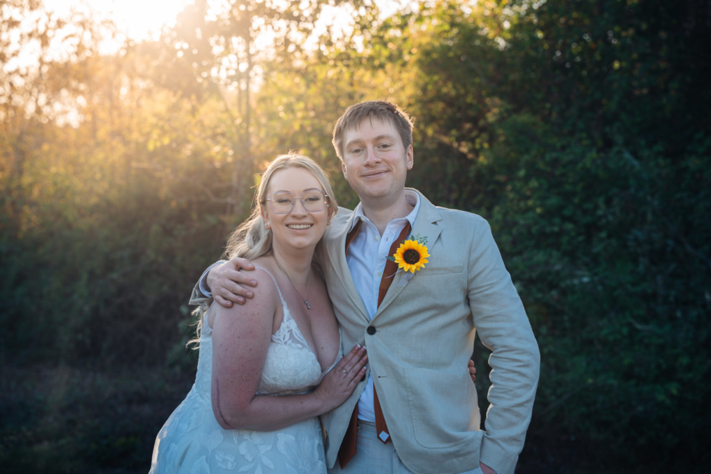 Couple smiling together, the groom wearing a sunflower buttonhole, a result of following simple wedding photography tips