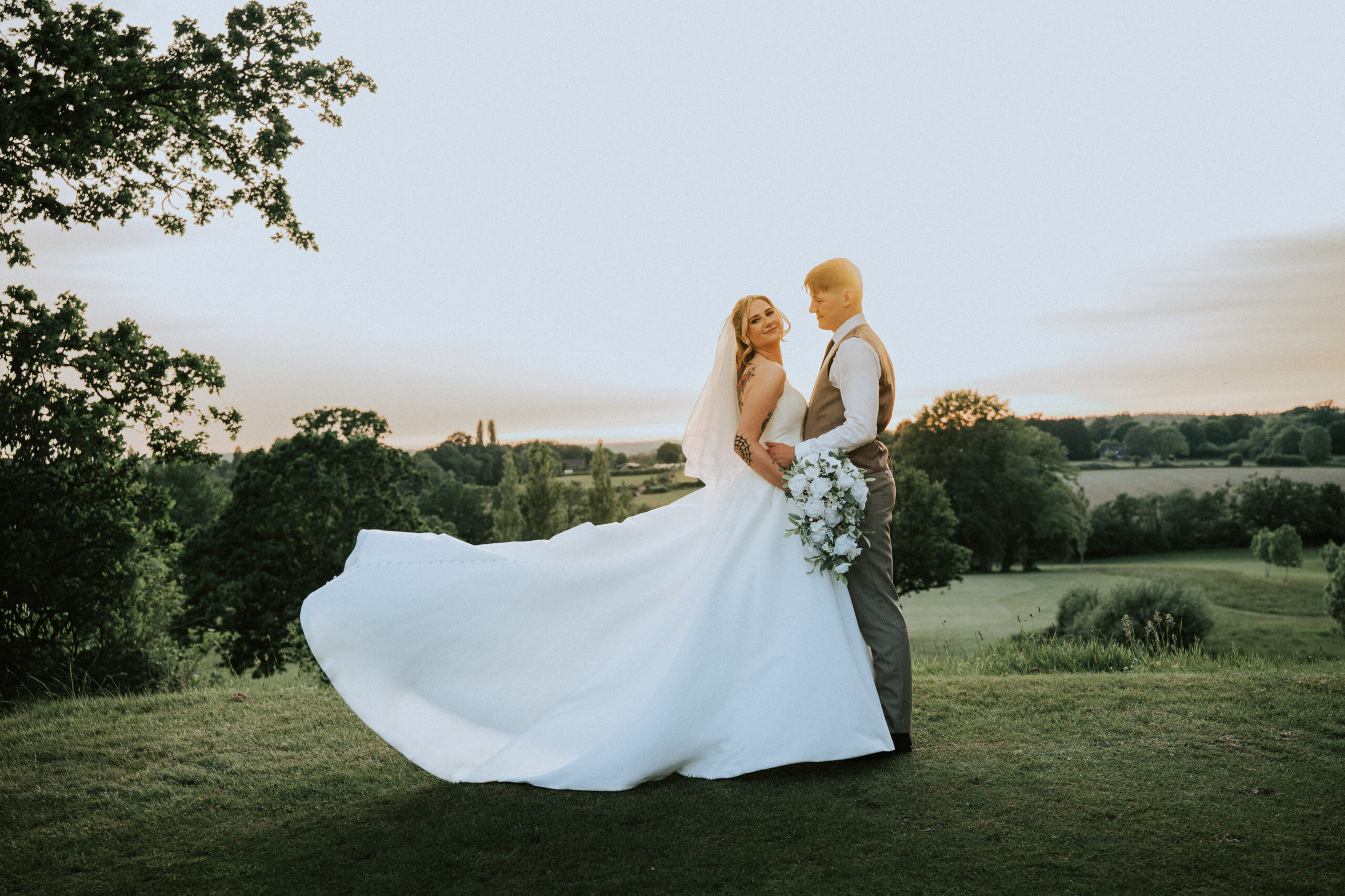 Bride and groom walking across the lawns of a country house, one of the wedding venues in Fareham style settings